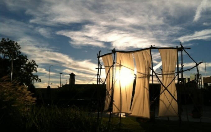 Outdoor photograph with fabric walls and the setting sun.